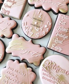 some pink and gold decorated cookies are on a white table with words written across them