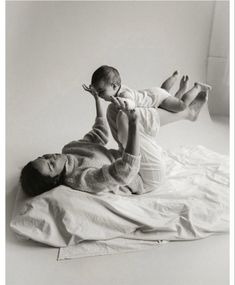 a woman laying on top of a bed holding a baby