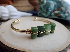 ✦ DETAILS ✦✧ Genuine Natural Nephrite Jade Crystals✧ Stones measure approx. 11x8mm but each stone is different ✧ Gold plated bangle cuff.✧Also available in amazonite, apatite, black tourmaline, and kyanite✧Usually ships same day or next day and comes ready for gifting in a cute boho gift box.For thousands of years, the stone has been revered in China and other countries throughout the world. The Chinese believed that since jade objects lasted so long, they were linked to immortality. They believ Spiritual Green Bangle Cuff Bracelet, Adjustable Green Cuff Bracelet With Natural Stones, Green Gemstone Bangle Cuff Bracelet, Jade Gemstone Bangle As Gift, Green Bangle With Natural Stones For Gift, Spiritual Jade Bangle For Gift, Green Gemstone Cuff Bracelet For Gift, Green Stone Bracelet, Jade Bangle Bracelet