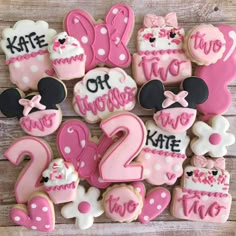 mickey mouse cookies with pink and white frosting are arranged in the shape of numbers