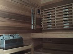 the inside of a sauna with wood slats on the wall and rocks in the bottom drawer