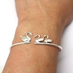 "Silver Mother and Child Swan Bracelet is handmade with its own uniqueness. It can be bought as a gift for any occasion like birthday gift, wedding gift, travel gift, souvenir and etc. If you need rose gold plating or yellow gold plating, please contact us, we will advice you on the additional fees applicable. Base Material: Sterling Silver Size: 15mm (Approximately) Bangle wrist size: Adjustable / Please give us your wrist circumference. Thickness: 1.5mm / 0.059 Inch Metal Stamped: 925 Crafting Whimsical Handmade Bracelets For Gifts, Novelty Bracelet Jewelry As Gift, Handmade Whimsical Bracelets As Gift, Novelty Bracelet Jewelry For Gifts, Novelty Bracelet Jewelry Gift, Cute Handmade Bracelets For Mother's Day, Cute Silver Bracelet For Birthday Gift, Cute Handmade Jewelry For Mother's Day, Handmade Adjustable Whimsical Bracelets