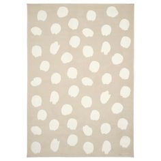 a beige and white rug with large dots on the top, in various sizes and colors