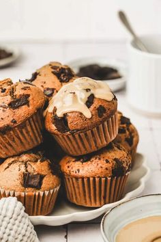 chocolate chip muffins with icing on a white plate