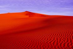 red sand dunes with blue sky in the background