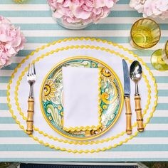 a place setting with plates, silverware and flowers