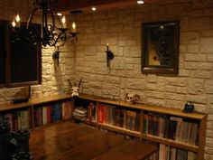 a room with a table, bookshelf and chandelier on the wall