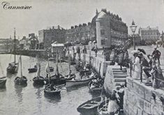 an old black and white photo of boats in the water next to a city wall