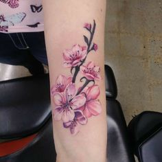 a woman's arm with pink flowers on it