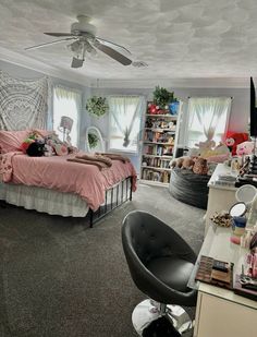 a bedroom with a bed, desk and chair in it next to a book shelf