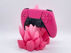 a pink controller sitting on top of a flower