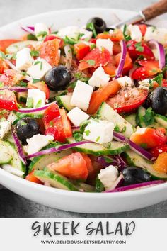 greek salad in a white bowl with olives, tomatoes, cucumbers and feta cheese