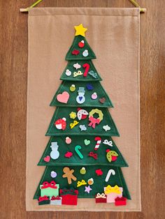 a felt christmas tree hanging on a wall