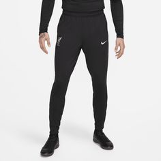 a man in black nike pants standing with his hands on his hips and looking at the camera