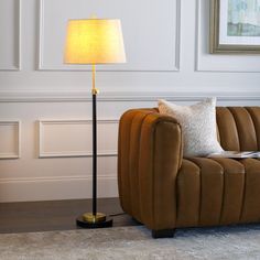 a living room scene with focus on the floor lamp and sofa in the foreground