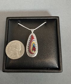 This is a beautiful piece of vette sports car fordite from the Bowling Green KY plant in the early 2000's that I cut and crafted a solid sterling setting for. This fordite necklace would make a great special gift for someone who appreciates handmade art. Check out the pattern I added to the back of the pendant. I even incorporated recycled silver into this piece. The included chain is 20 inches in length and is also solid silver. It's one of the most valuable and desired fordite types. If you lo Red Sterling Silver Jewelry With Inlay, Collectible Jewelry With Large Teardrop Pendant, Inlay Pendant Jewelry Gift, Artisan Teardrop Inlay Jewelry, Inlay Pendant Jewelry For Gift, Pendant Jewelry With Inlay As Gift, Oval Inlay Necklace Gift, Oval Necklace With Inlay As Gift, Artisan Oval Necklace With Inlay