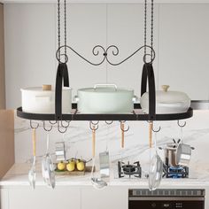 a kitchen with pots and pans hanging from the ceiling over the stove top oven