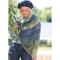 a woman wearing a knitted shawl and holding a tree branch in front of her