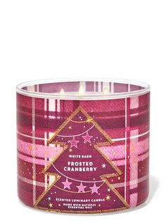 a candle in a glass container with pink plaid and stars on the bottom, next to a