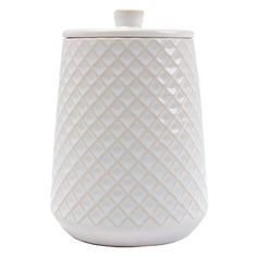 a white ceramic jar with a lid on the top and an intricate pattern around it