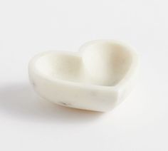 two white heart shaped bowls sitting on top of a table