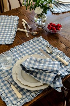 a wooden table topped with plates and silverware