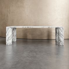 two marble benches sitting next to each other on top of a cement floor in front of a beige wall