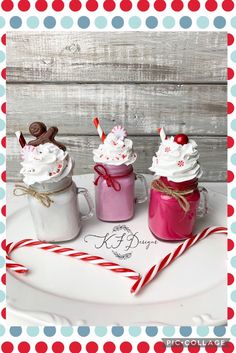 three mason jars filled with whipped cream and candy canes on top of a white plate