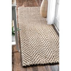 the rug is made from jute and has a chevron pattern on top of it