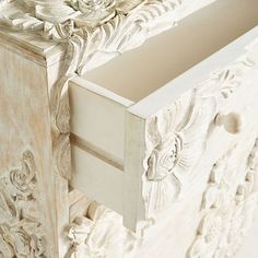 an ornate white dresser with drawers and knobs