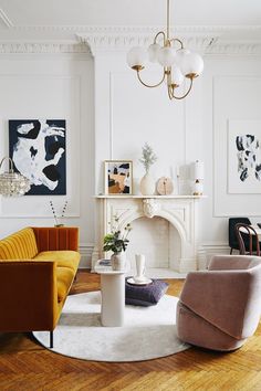 a living room filled with furniture and a fire place under a chandelier above a fireplace