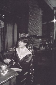 black and white photograph of a woman sitting at a table