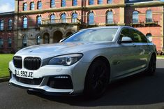 a silver car parked in front of a large building