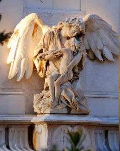 an angel statue on the side of a building