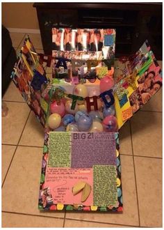 a birthday cake made out of balloons and pictures with candles in the middle, on a tile floor