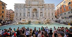 a crowd of people standing in front of a fountain