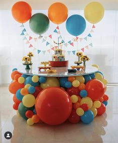 a table topped with balloons and a cake