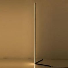 a floor lamp that is lit up in the middle of a room with no lighting