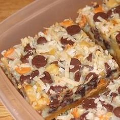 a plastic container filled with lots of different types of desserts on top of a wooden table