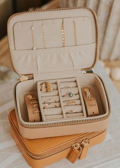 an open suitcase filled with jewelry on top of a table