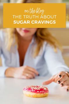 a woman sitting at a table with a doughnut in front of her and the words on the blog, the truth about sugar cravings