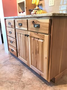 a kitchen island made out of wood with drawers and knobs on the front door