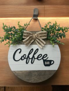 coffee bar sign hanging on the side of a wooden wall with plants growing out of it