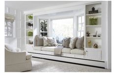 a living room filled with lots of white furniture