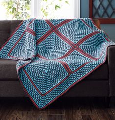 a blue and red blanket sitting on top of a couch