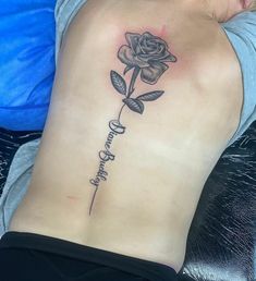 a woman's lower back with a rose tattoo