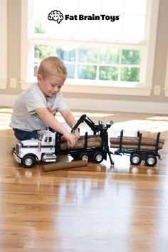 a young boy playing with toy trucks on the floor