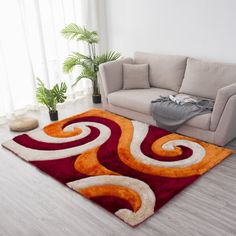 a living room area with a couch and rugs on the floor in front of a window