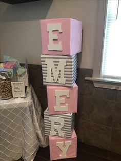 a pink and grey block that says merry on it in front of a table with other items