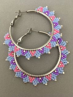 This is a pair of 2 inch hoop earrings.  They are made with pink, purple lt. blue, and silver delica beads.  The hoops are stainless steel. Small Silver Hoop Earrings With Colorful Beads, Delica Beaded Hoop Earrings, Silver Small Hoop Earrings With Colorful Beads, Pink Hoop Beaded Earrings, Purple Beaded Round Hoop Earrings, Blue Beaded Metal Hoop Earrings, Rainbow Colorful Beaded Hoop Earrings, Weaving Earrings, Nickel-free Pink Beaded Hoop Earrings